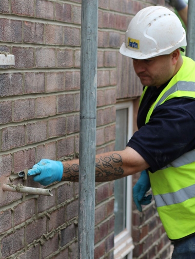 CPM Contracts Employee pointing a wall.